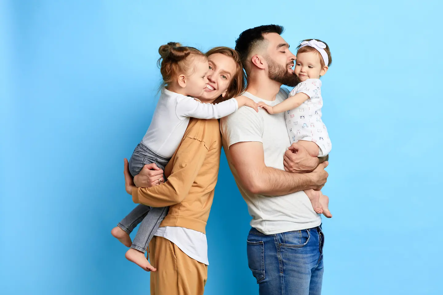 A family of 4 in front of a blue background.